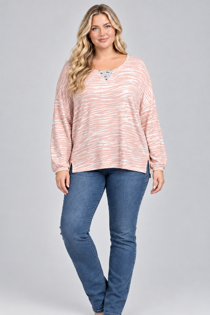 Studio front view of the blonde XL model wearing the blush striped top and blue jeans