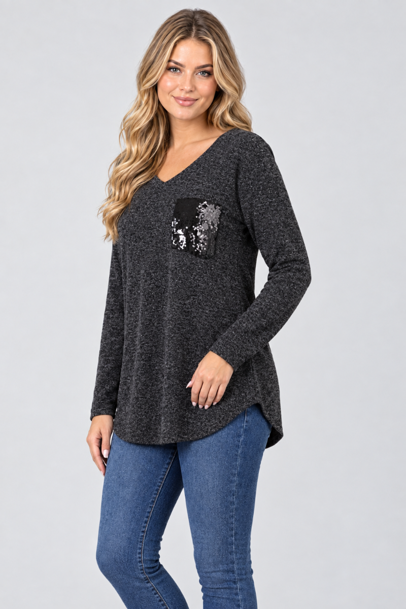 Studio side view of new blonde model in charcoal heather tunic and blue jeans