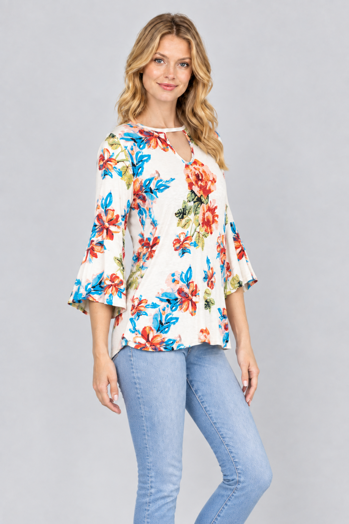 Three-quarter studio view of the blonde model wearing the ivory floral keyhole blouse and light-wash jeans