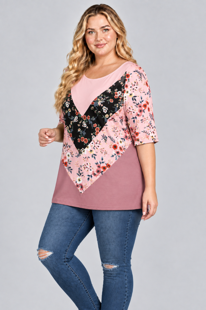 Three-quarter studio view of the blonde plus-size model wearing the pink floral color-block tunic