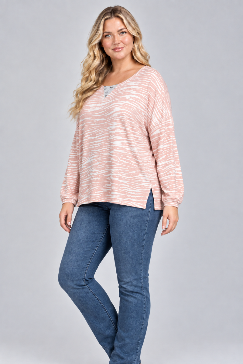 Three-quarter studio view of the blonde XL model wearing the blush striped top and blue jeans