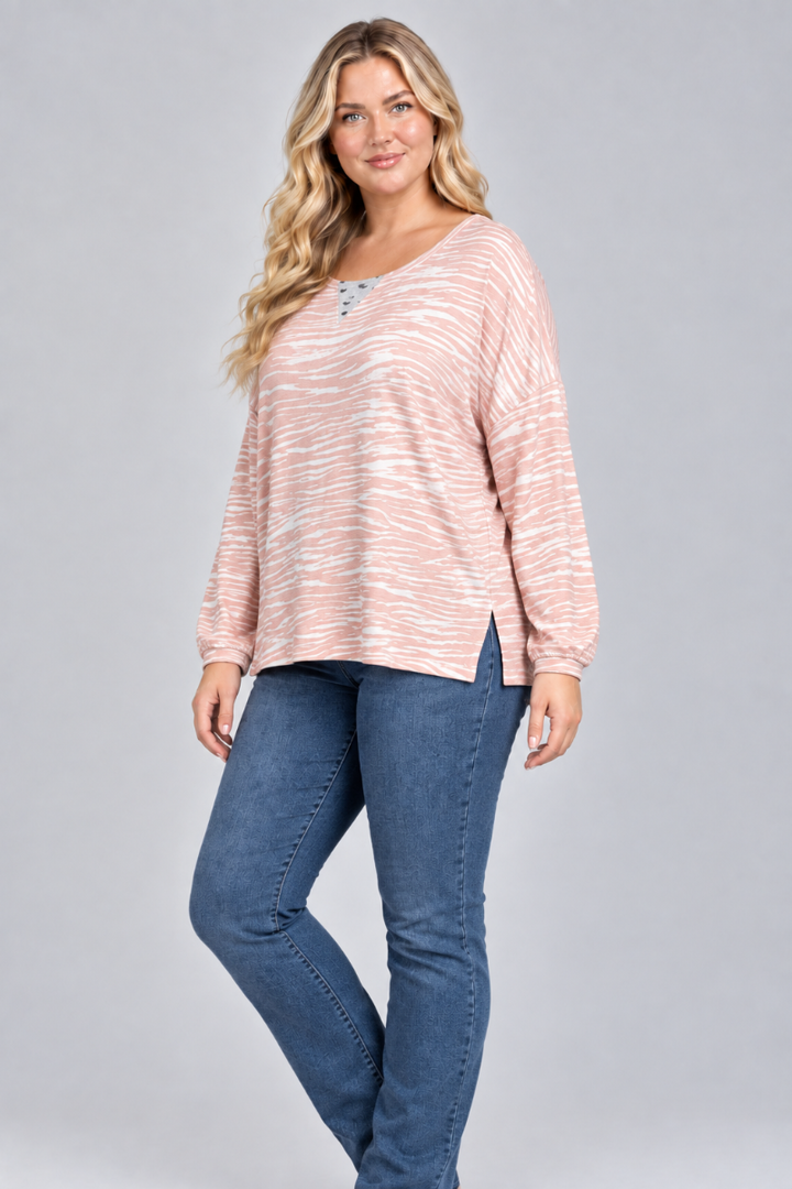 Three-quarter studio view of the blonde XL model wearing the blush striped top and blue jeans