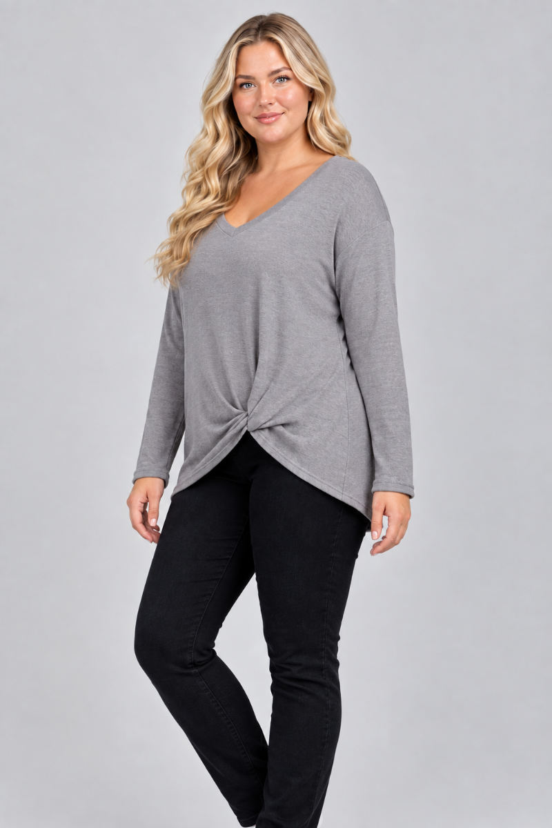Three-quarter studio view of the blonde XL model wearing the gray twist-front top and black pants
